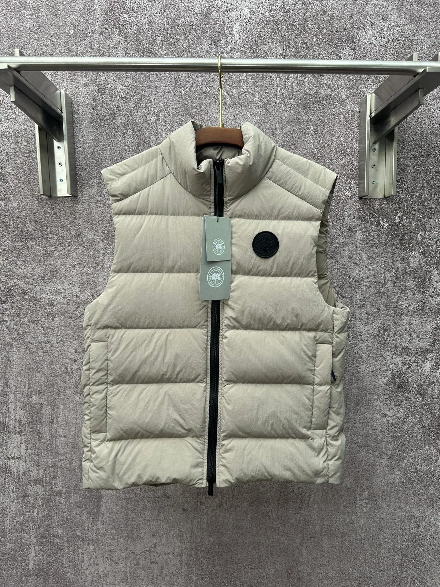 P720 Canada Goose Badge Down Vest Fabric selection: The use of high-quality protective nylon fabric not only enhances the wear resistance of the surface, but also takes into account wind resistance, ensuring excellent performance in various harsh weather conditions.  90 national standard high-quality white duck down: selected high-loft down, weighing 160g, light and warm, with excellent temperature locking performance and good resilience.  Three-dimensional quilting process: Precision thread reinforcement to prevent velvet drilling and ensure that the fluffy and resilient elasticity lasts as new.  Details: The ribbon is woven with polyester as the base, and the brand letters are decorated on the ribbon through high-precision computer embroidery. The edges of the pattern are clear, the stitches are fine and even, and multiple layers of embroidery thread are stacked to enhance the three-dimensional effect. Accessories: One-to-one customized logo, one-to-one customized zipper puller, one-to-one customized three-label SIZE: S M L XL